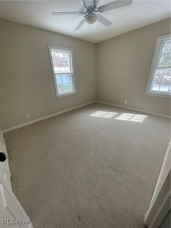 spare room featuring ceiling fan, baseboards, and carpet flooring