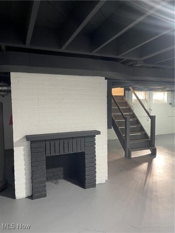 basement featuring stairs and a fireplace