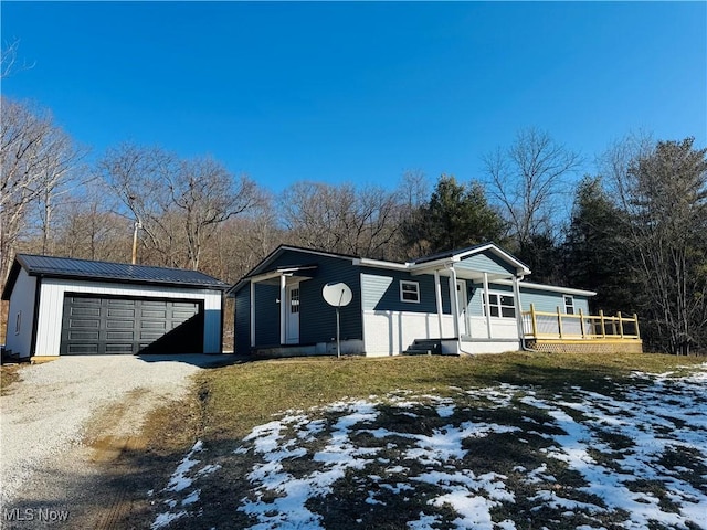 view of front of home with an outbuilding, metal roof, covered porch, a lawn, and a standing seam roof