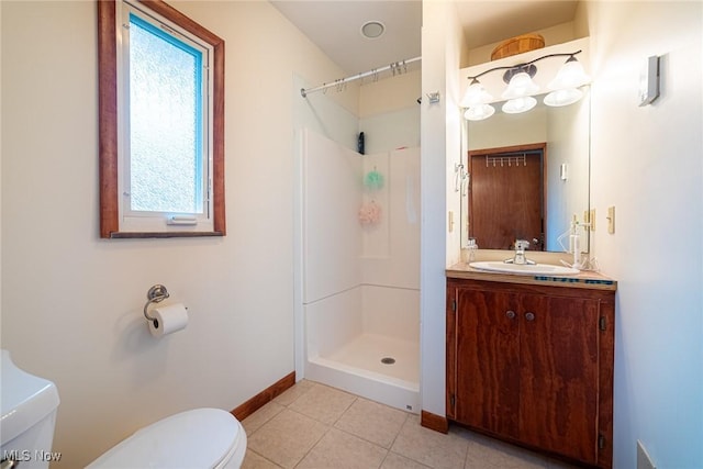 full bathroom featuring baseboards, toilet, tile patterned flooring, vanity, and a shower stall