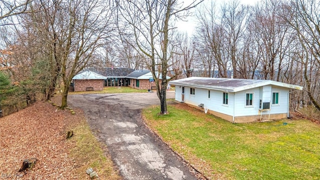 ranch-style home with driveway and a front yard