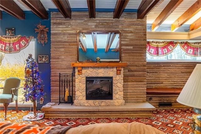 unfurnished living room with visible vents, a fireplace, and beamed ceiling