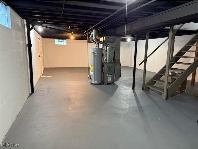 below grade area with stairway, gas water heater, concrete block wall, and heating unit