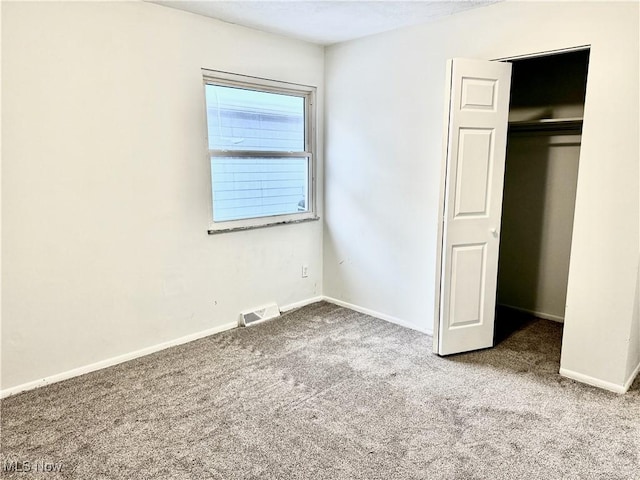 unfurnished bedroom with light carpet, baseboards, visible vents, and a closet