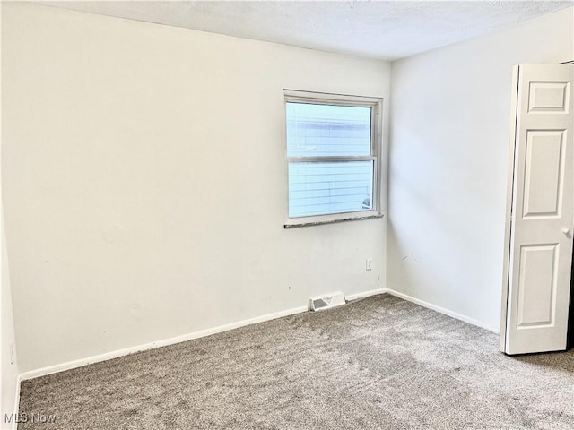 carpeted empty room with baseboards and visible vents