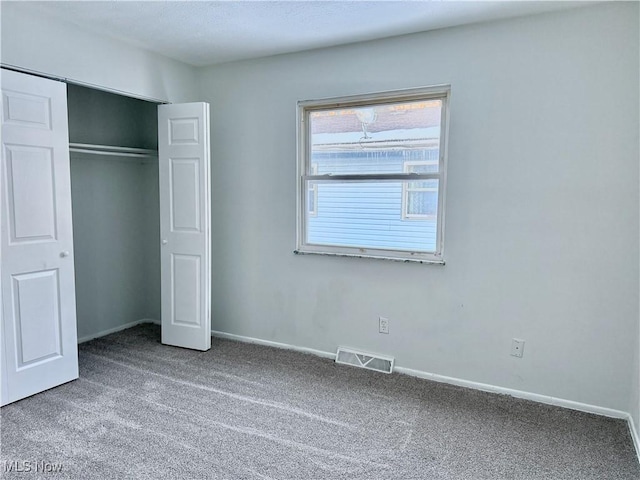 unfurnished bedroom featuring a closet, carpet, visible vents, and baseboards