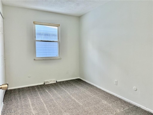 unfurnished room featuring a textured ceiling, carpet flooring, visible vents, and baseboards