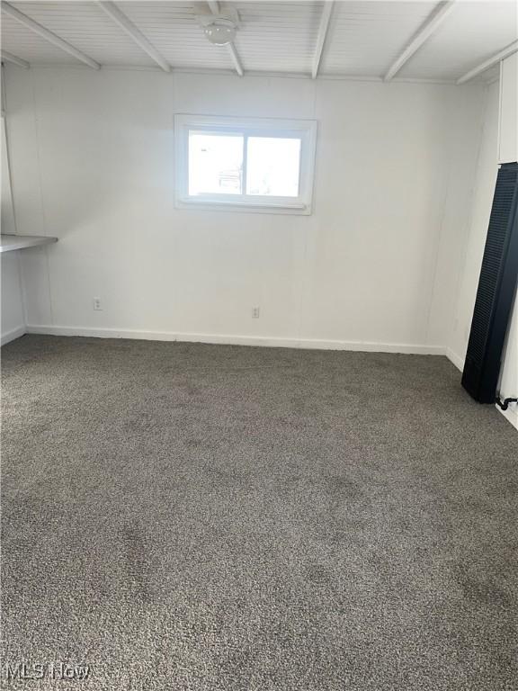 carpeted empty room featuring baseboards