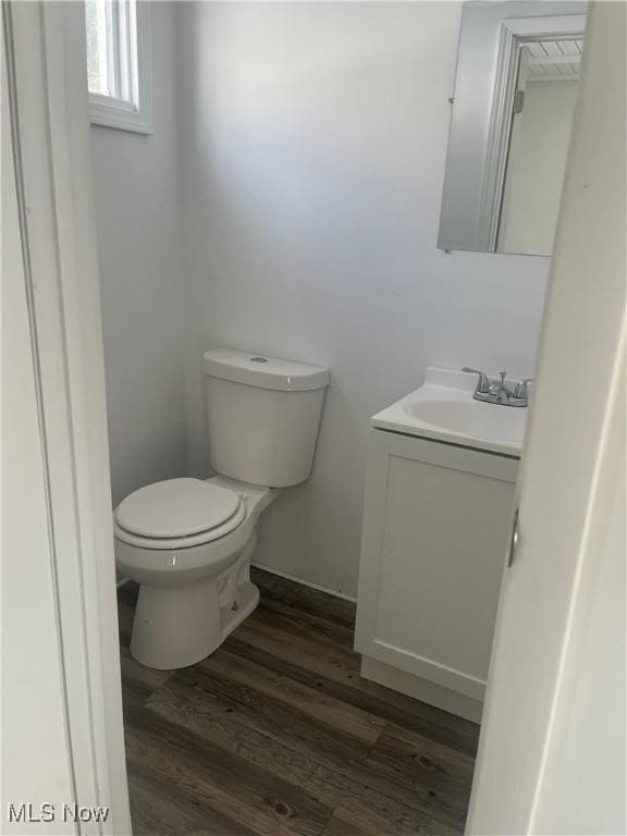 bathroom featuring vanity, wood finished floors, toilet, and baseboards