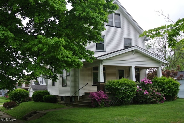 view of front of home with a porch and a front yard