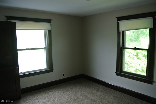 carpeted spare room with a wealth of natural light and baseboards