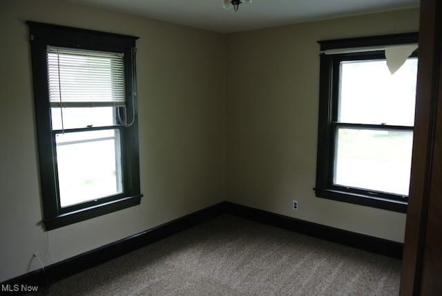 carpeted spare room with baseboards and a healthy amount of sunlight