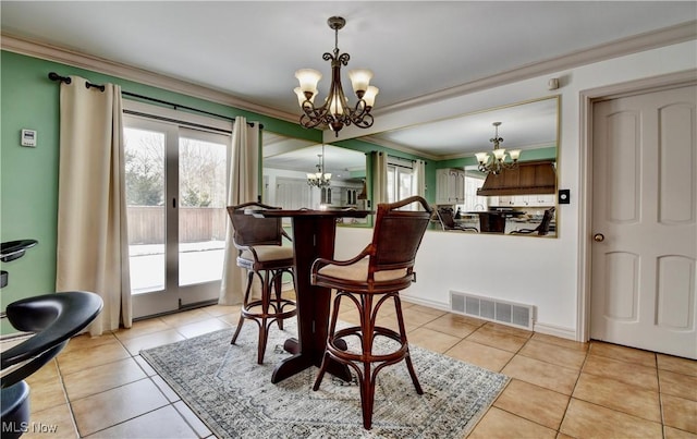 dining room with ornamental molding, visible vents, and a notable chandelier