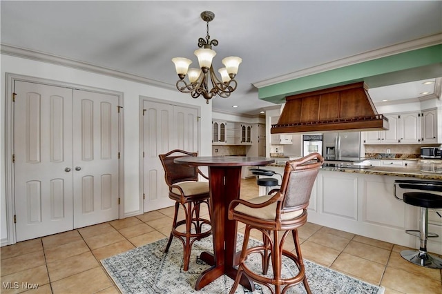 dining room featuring ornamental molding, an inviting chandelier, and light tile patterned floors