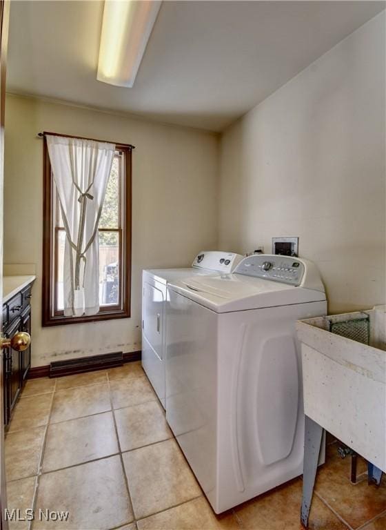 laundry area featuring light tile patterned floors, a sink, washer and dryer, laundry area, and baseboards