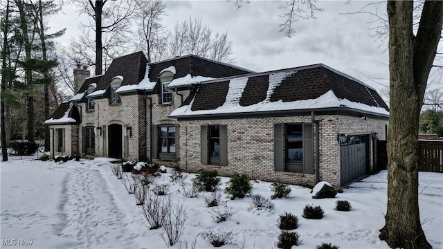 view of front of home with brick siding and mansard roof