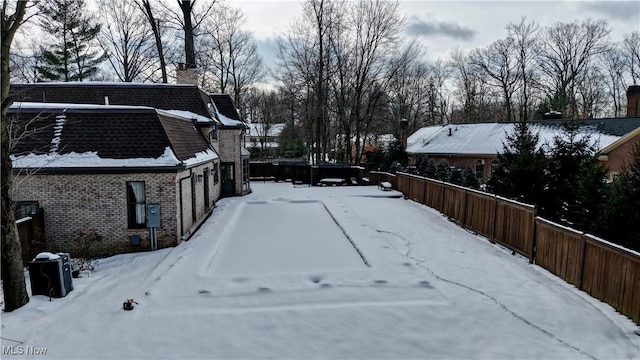 yard layered in snow with a garage and fence