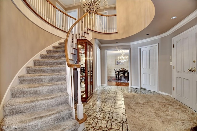 entryway with recessed lighting, a high ceiling, ornamental molding, a chandelier, and baseboards