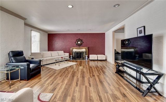 living room with recessed lighting, a fireplace, wood finished floors, baseboards, and crown molding