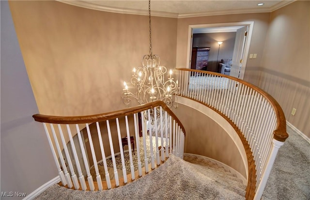 staircase with a chandelier, ornamental molding, carpet flooring, and baseboards