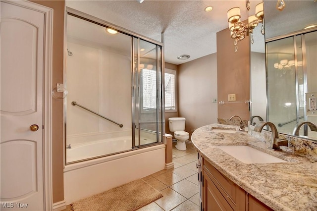 full bath featuring double vanity, a sink, a textured ceiling, and bath / shower combo with glass door