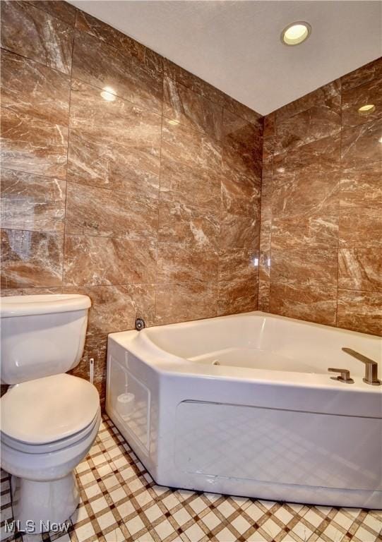 full bath with recessed lighting, tile walls, toilet, and a bath