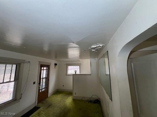 empty room featuring baseboards and dark colored carpet