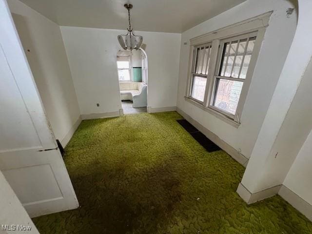 unfurnished dining area with carpet and baseboards