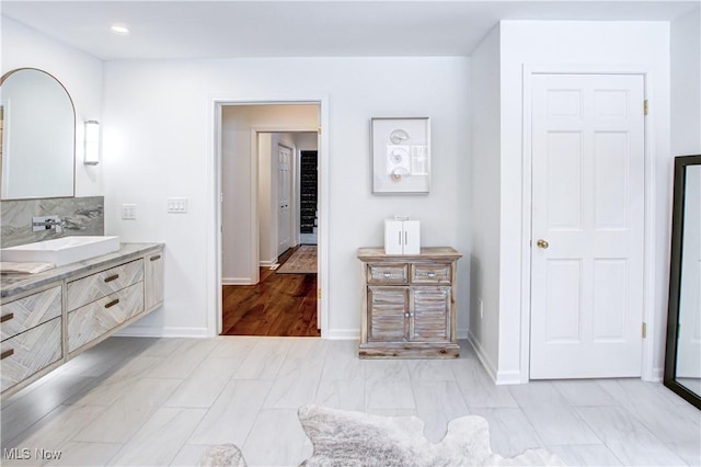 full bath featuring baseboards, decorative backsplash, and vanity