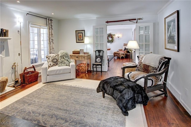 sitting room featuring ornamental molding, dark wood finished floors, and baseboards