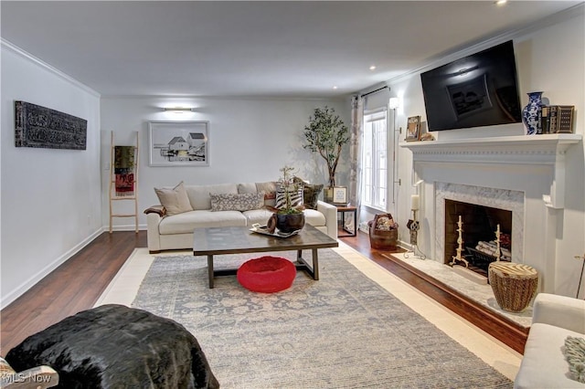 living room with dark wood-style floors, baseboards, a premium fireplace, and ornamental molding