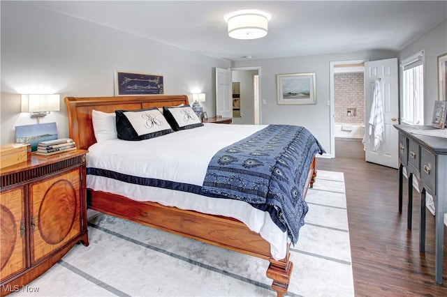 bedroom with wood finished floors and connected bathroom