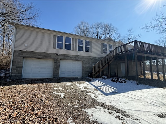 exterior space featuring an attached garage, driveway, stairs, and a wooden deck