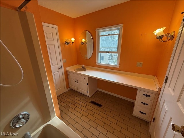 full bathroom featuring brick floor, vanity, visible vents, and baseboards