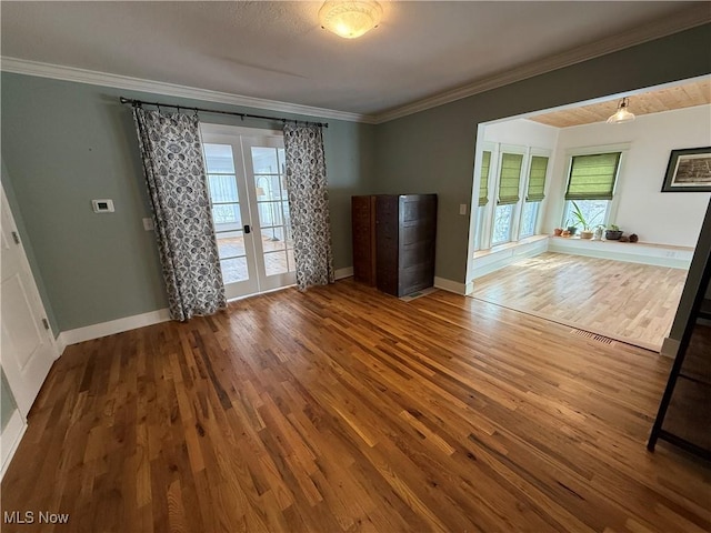 unfurnished living room with french doors, wood finished floors, and crown molding