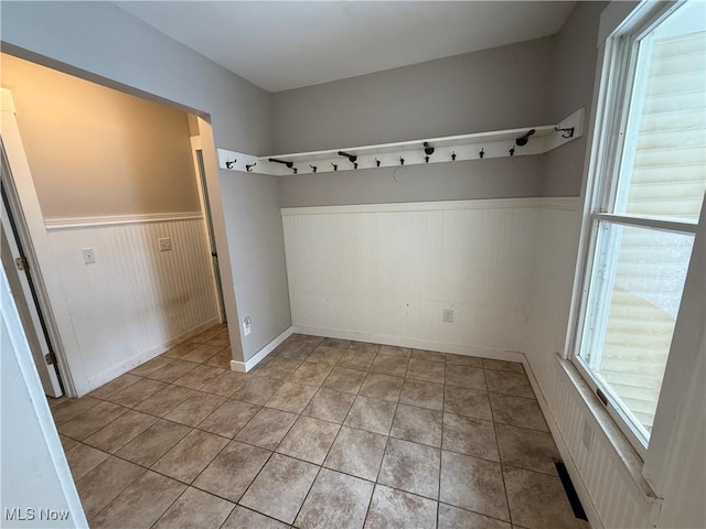 mudroom featuring light tile patterned flooring and wainscoting