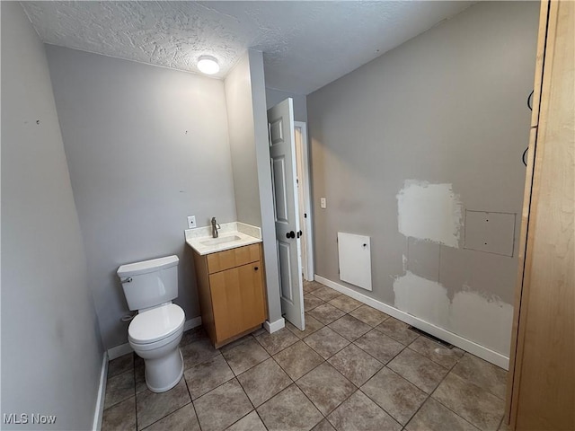 half bathroom featuring baseboards, a textured ceiling, toilet, and tile patterned floors