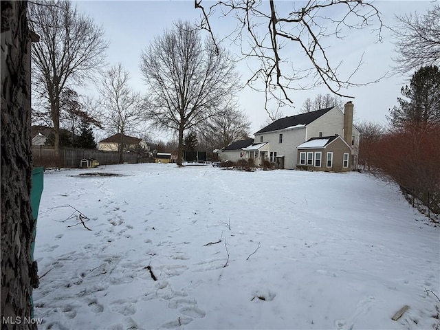 yard covered in snow with fence