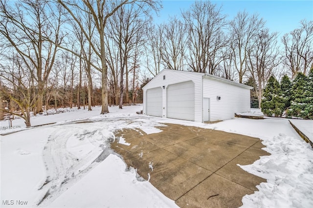 snow covered garage featuring a garage