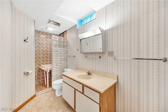 bathroom with tile patterned floors, vanity, toilet, and wallpapered walls