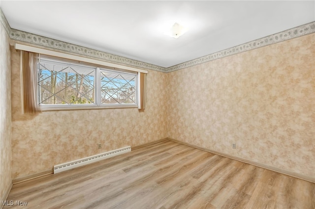 empty room featuring light wood finished floors, a baseboard radiator, and wallpapered walls