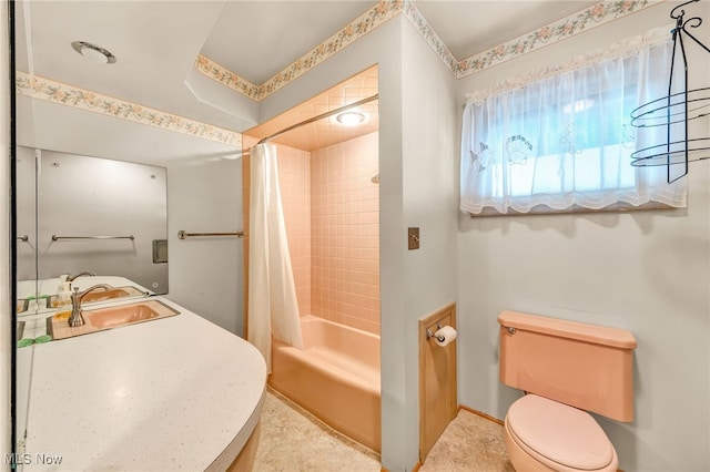 bathroom featuring toilet, shower / tub combo, and a sink