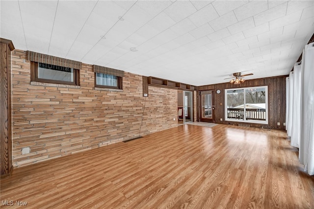 unfurnished living room with visible vents, a ceiling fan, and wood finished floors