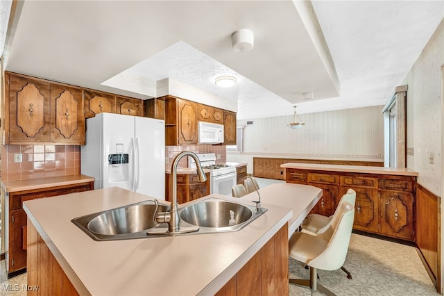 kitchen featuring white appliances, brown cabinetry, light countertops, and a center island