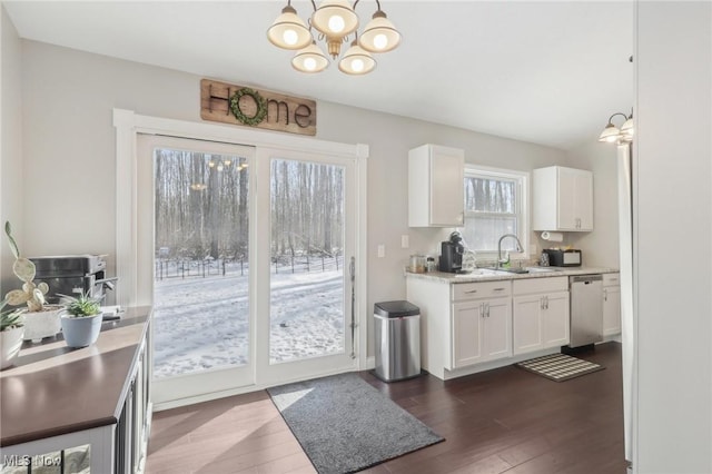 kitchen featuring dishwasher, hanging light fixtures, and white cabinetry