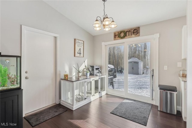 doorway to outside featuring lofted ceiling, a notable chandelier, and dark wood-type flooring