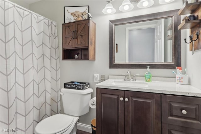 full bath with curtained shower, vanity, and toilet