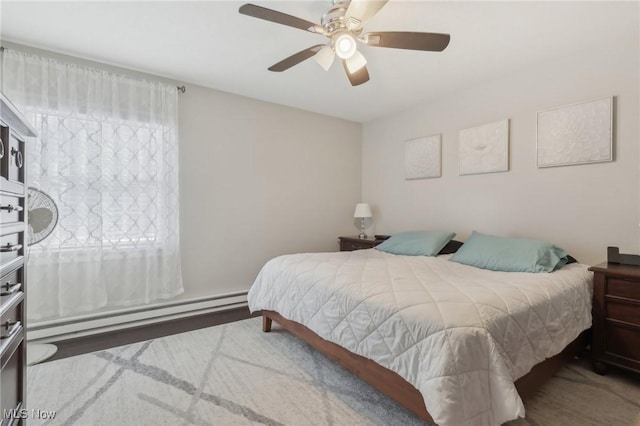 bedroom featuring ceiling fan and a baseboard heating unit