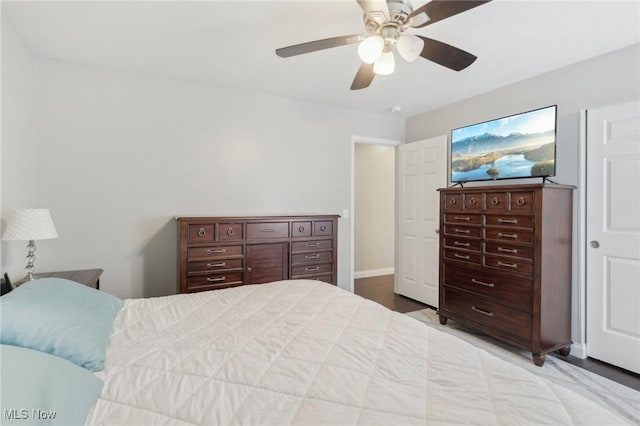 bedroom with a ceiling fan, baseboards, and wood finished floors