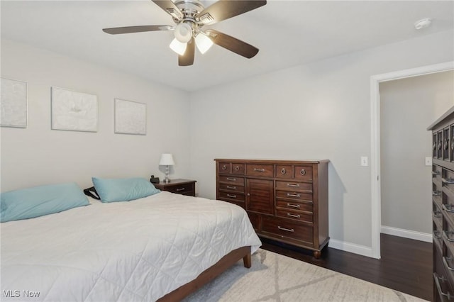 bedroom featuring a ceiling fan, baseboards, and dark wood-style flooring